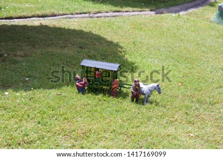Model horse, gypsy caravan and family on grass Royalty-Free Stock Photo #1417169099