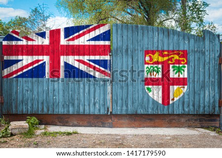 Close-up of the national flag  Fiji on a wooden gate at the entrance to the closed territory on a summer day. The concept of storage of goods, entry to a closed area, tourism in Fiji