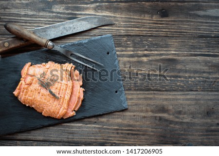 Sliced smoked salmon with dill over a rustic wood table background. Image shot from top view or flat lay position.