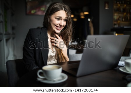Beautiful woman working with laptop in a cafe.