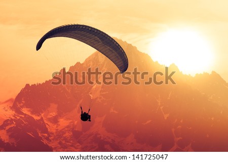 Sepia paraglide silhouette over Alps peaks Royalty-Free Stock Photo #141725047