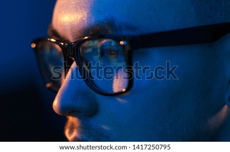 vision, hacking and technology concept - close up of hacker eyes in glasses looking at computer screen in darkness Royalty-Free Stock Photo #1417250795