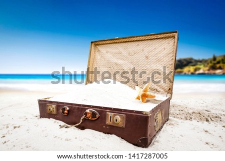 Summer suitcase on beach and ocean landscape. Free space for your decoration and blue sky 