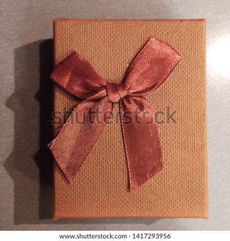 Macro photo gift box with bow. Texture background brown box with gift tied with a ribbon and a bow