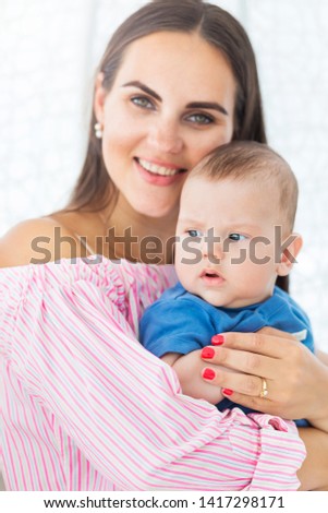 beautiful mother holds in her arms a little son
