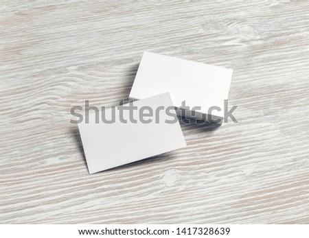 Blank business cards template on light wood table background. Template for graphic designers portfolios.