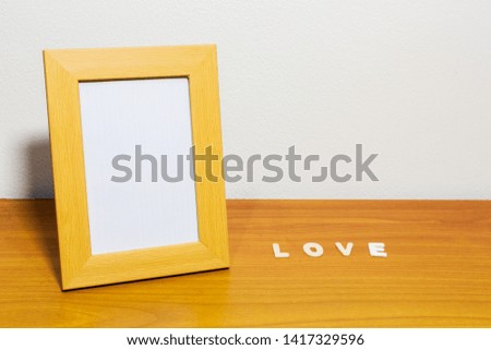 Picture frame on a wooden table with the word love