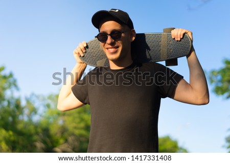 guy at sunset in a cap and sunglasses.
Man Skateboarder Lifestyle Relax. Hipster Concept.
