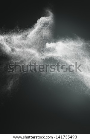 Abstract design of white powder cloud against dark background Royalty-Free Stock Photo #141735493
