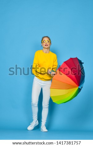 woman in a yellow jacket holding a beautiful umbrella                               