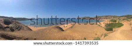 Landscape picture of a blue beach brown sand in Menorca