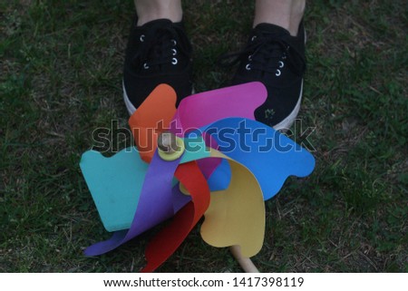 amazing, colorful kids toy, colorful windmill, photo, picture from outside, with a womans legs next to it, great wallpaper