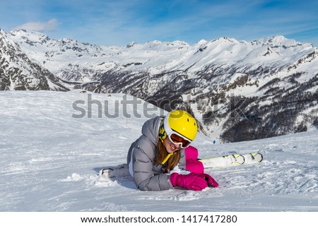 Little girl learning to ski on the ski slopes in the high mountains