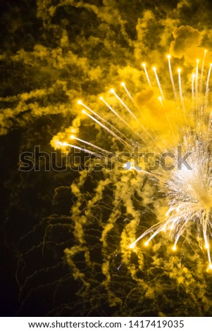 Yellow sparkles and smoke from celebration fireworks