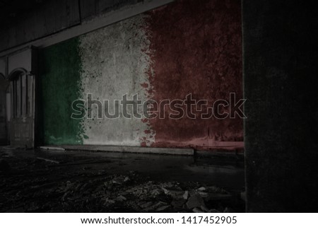 painted flag of italy on the dirty old wall in an abandoned ruined house. concept