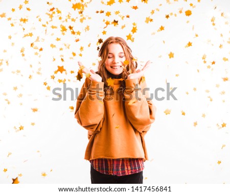Cute teen girl on a light background throws color candy. Party concept.