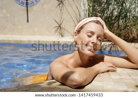 Portrait of stunning woman relaxing in luxurious pool