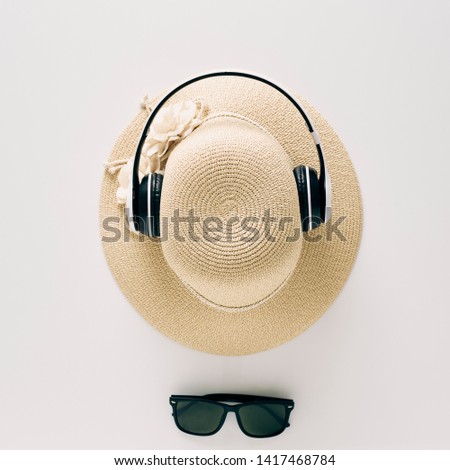 Summer holiday background, flat lay beach women's accessories: straw hat, headphones, sunglasses on white background, with empty space for text. Travel and fashion concept. Vacation summer sales.