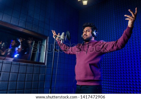 professional singing indian men headphones sound modern studio violet background recording song.