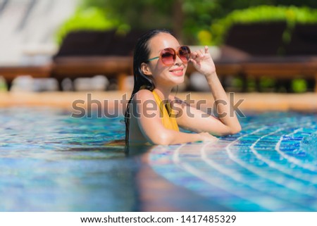 Portrait beautiful young asian woman leisure relax smile and happy around swimming pool in hotel resort for holiday vacation trip