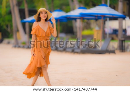 Portrait beautiful young asian woman happy smile relax on the beach sea ocean at sunset time in holiday vacation