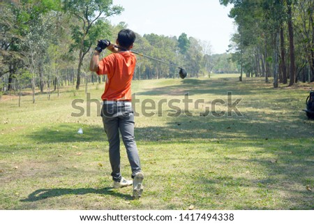 Golfer playing golf in the evening golf course, on sun set evening time. Man playing golf on a golf course in the sun.                                