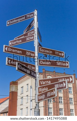 Sign pointing to many Hanseatic cities in Rostock, Germany