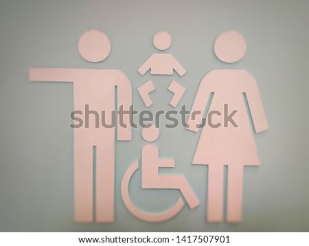 Blurred and defocused image of toilet sign (Male, Female, Baby diaper change and Disabled person) with blurred grey background.