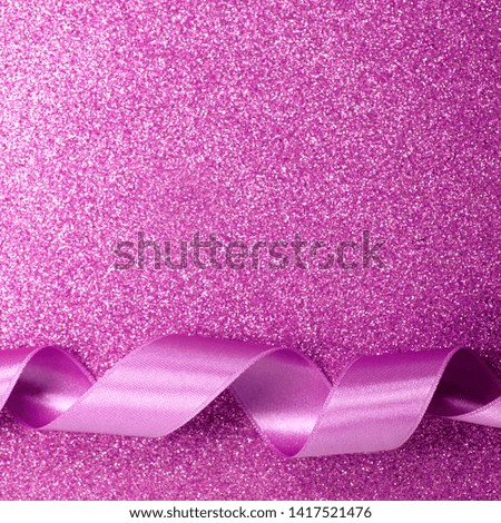 Fashionable satin pink ribbon on a purple background