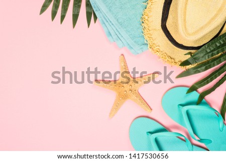 Summer flat lay background. Palm leaves, flip flops, pineapple, sunglasses, hat and starfish on pink background.