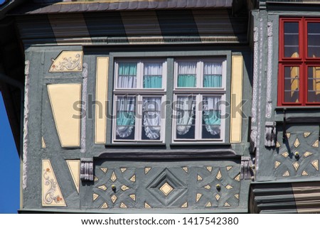 beautiful cutout of an old vintage half-timbered house with ornaments, windows with curtains (close up detail shot)