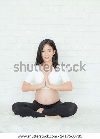Beautiful pregnant women sit on the bed and relax with exercise