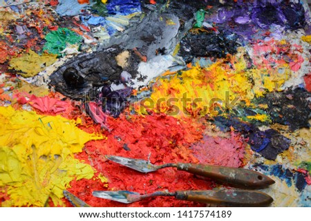 Zoom on a painter's palette in his workshop with tools