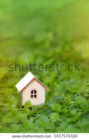 toy wooden house in green grass, abstract natural background. Symbol of family. Construction, rental housing, Mortgage, Real estate concept. Eco Friendly home. template for design