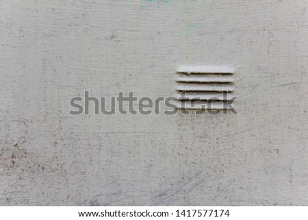 an old battered white metal wall with scratches and a small blinds grille. rough surface texture