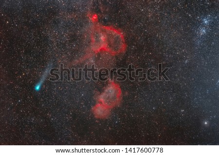 Space background with the image of a comet and cosmic nebulae. Photograph of a comet and red nebulae in space.