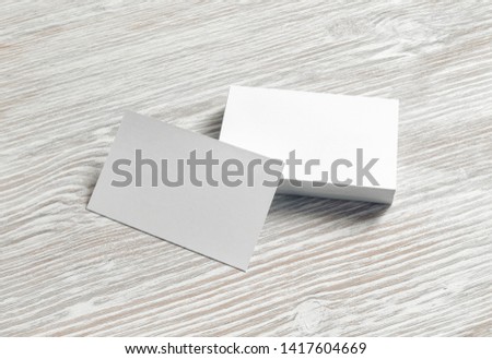 Mockup of blank white business cards on light wooden background. Branding identity template for graphic designers portfolios.