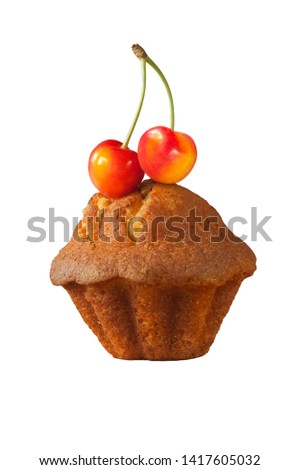 Two ripe sweet berries of a sweet cherry lie on top of a delicious delicious cupcake isolated on a white background.