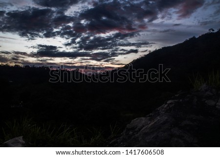 Stunning landscape of a sunset on the mountain with a cloudy sky and gradient game from blue to red