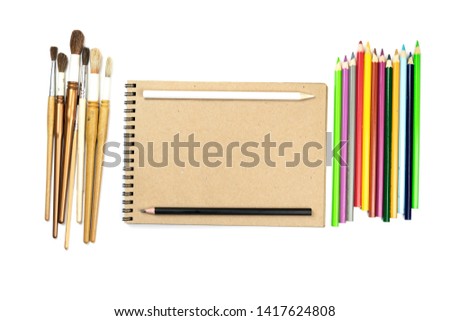 Watercolour brushes, coloured pencils and notebook isolated on white background for mockup. Concept: preparing for school.