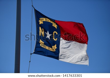 flag of north carolina waving on a flag pole