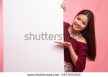 Young Asian woman present blank sign with palm hand on pink background