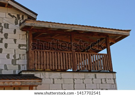 outdoor wooden balcony porch on a gray brick wall