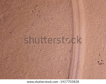 Aerial view of a desert landscape on the island of Lanzarote, Canary Islands, Spain. Road that crosses a desert. Dirt road. Formed by the crossing of off road vehicles