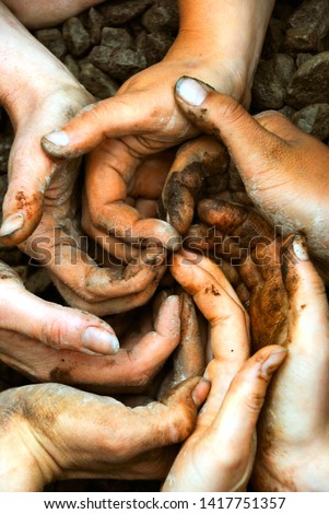A spiral of white hands full of brown dirt and soil inspiring cooperation, working together as a group, in a permaculture workshop, in Quebec, Canada Royalty-Free Stock Photo #1417751357