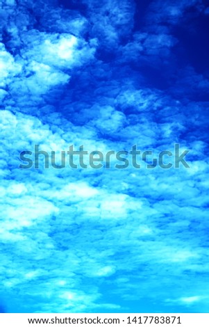 Abstract nature texture of white puffy & fluffy cumulus, cirrocumulus or altocumulus clouds on tropical summer or spring bright blue sky background in sunny & sunshine day, vertical image, copy space