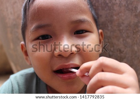 Small boy eating lollipop, candy, shooting blurred