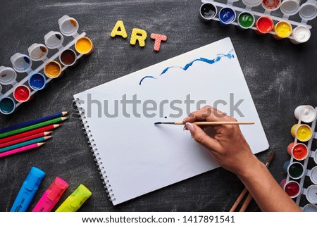Back to school. Items for the art on a black wooden table