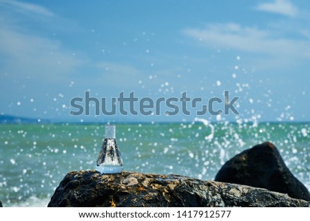 Glass bulb. Sea shore. Waves hit the stones.