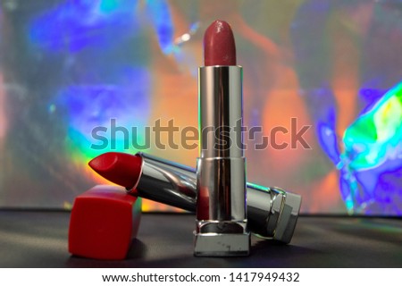 red lipstick on black table colorful background